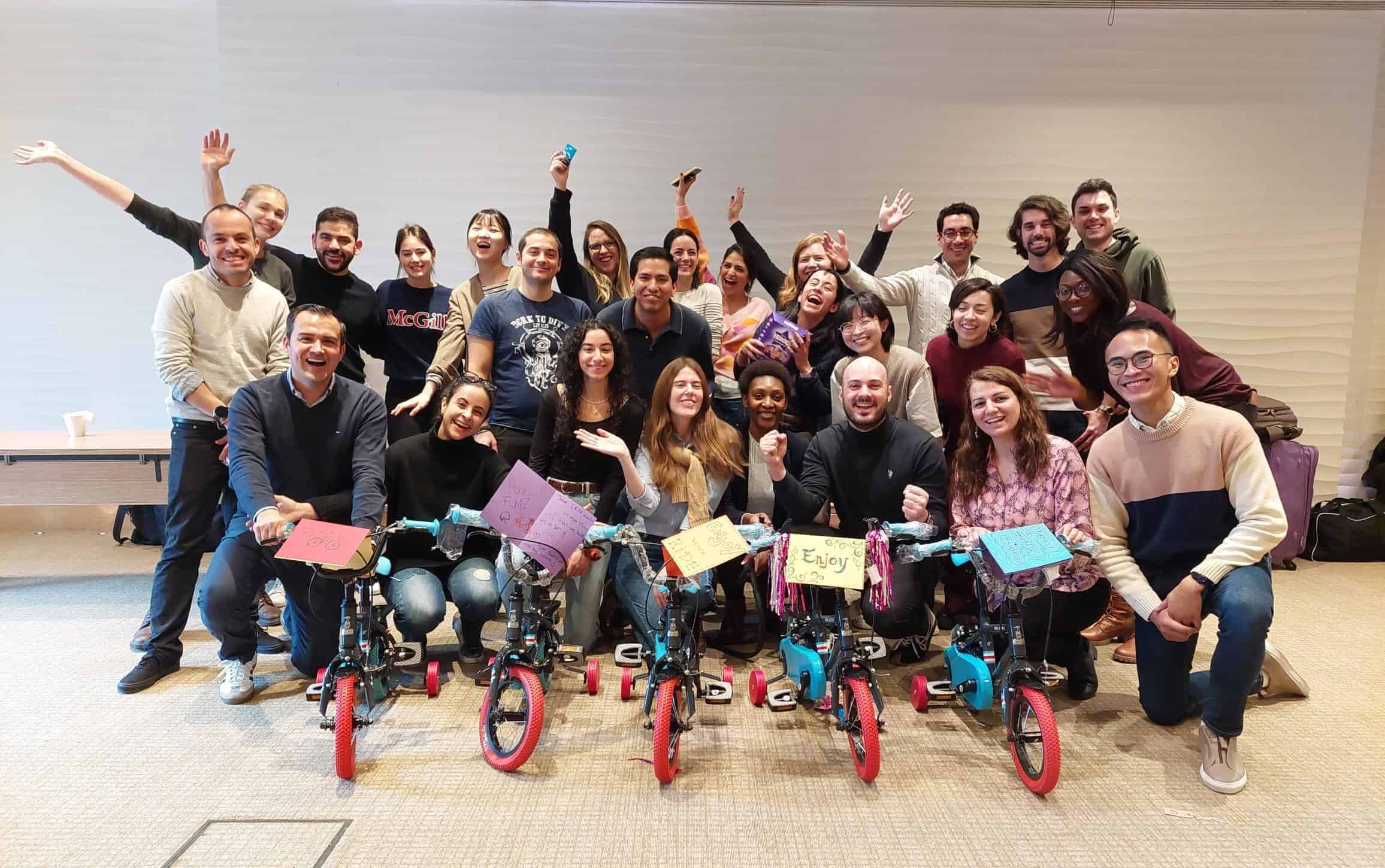 Build a Bike for Charity 11 A group photo of colleagues sitting and standing behind bikes they built for charity at a corporate event.