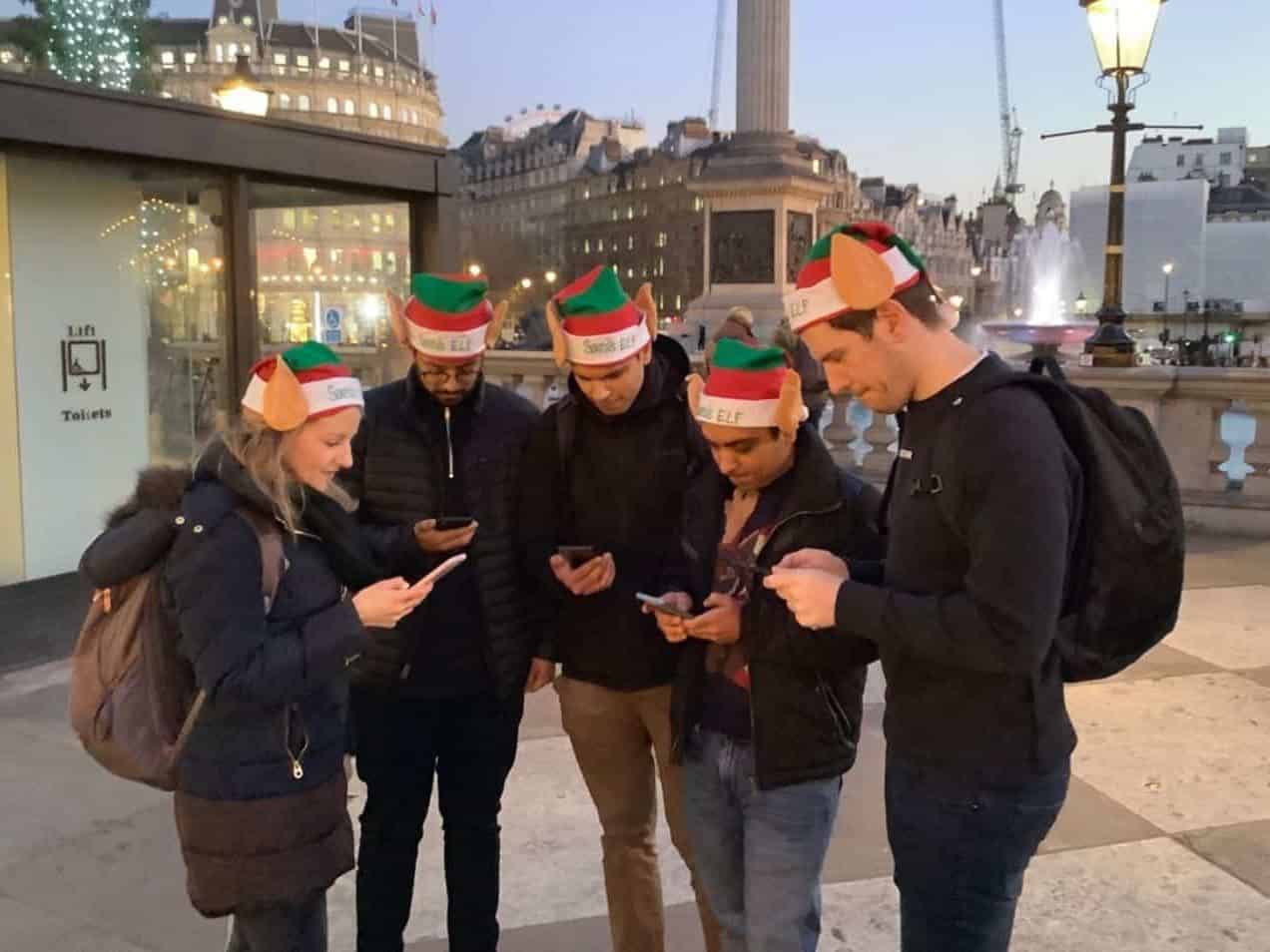 A team looking at their phones, in London, while on a treasure hunt