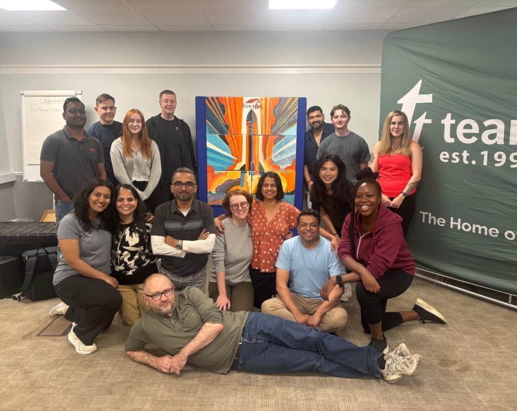 A team infront of their bigger picture hosted by team tactics