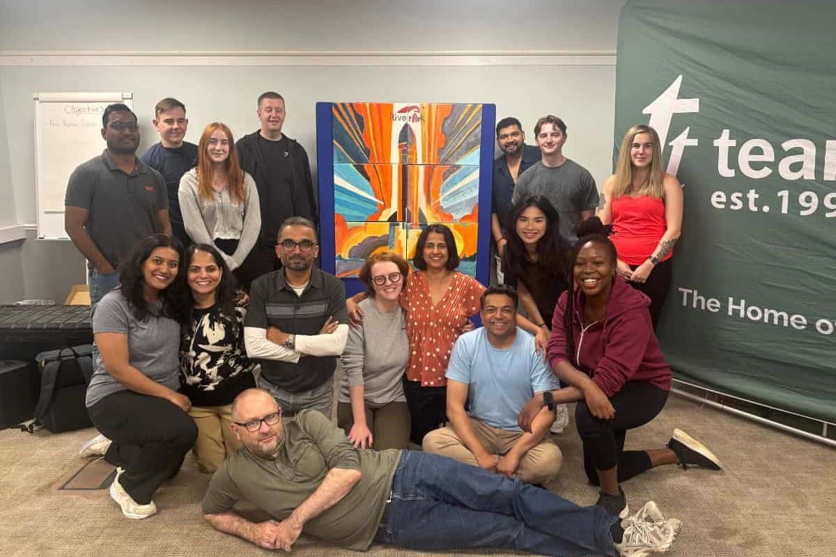 A team infront of their bigger picture hosted by team tactics