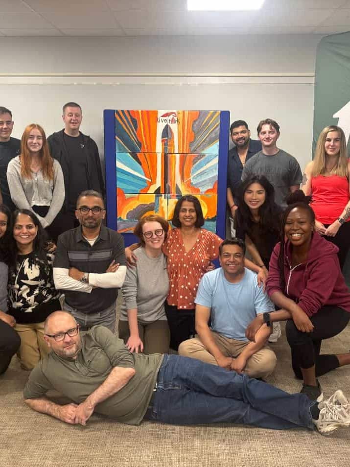 A team infront of their bigger picture hosted by team tactics