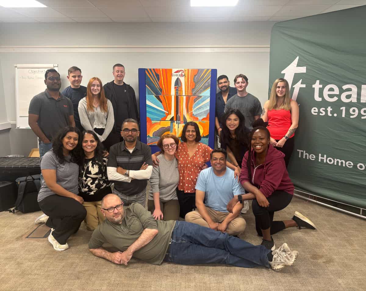 A team infront of their bigger picture hosted by team tactics